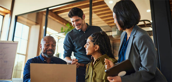 Group of people collaborating with a laptop in front of them